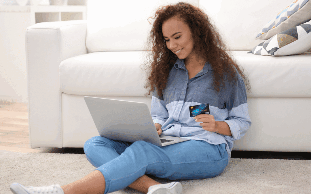woman smiling looking at laptop with credit card