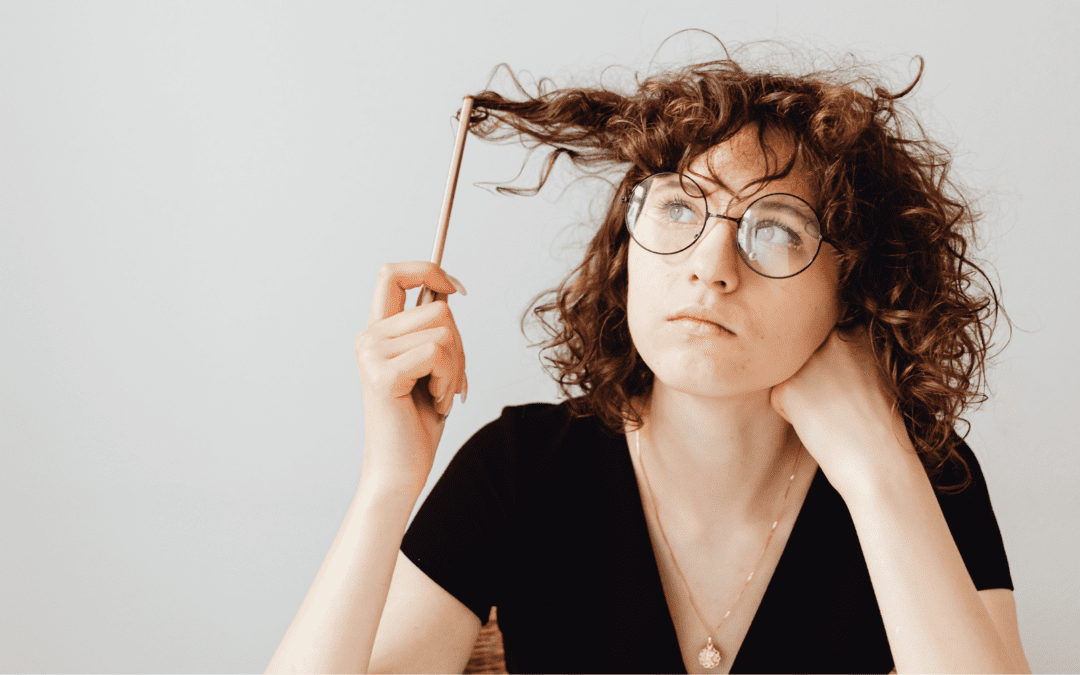 Woman with brown curly hair thinking